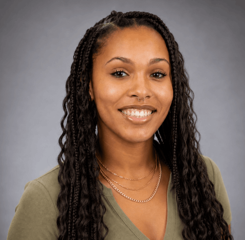 Shyan Cleveland smiling wearing a green shirt with a gray background